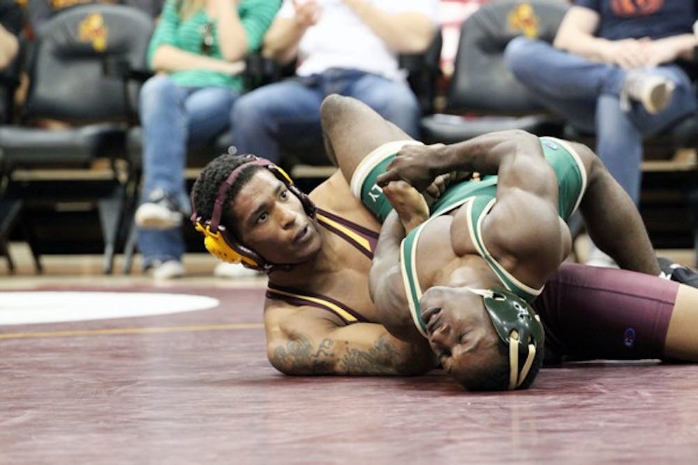 NO PLACE LIKE HOME: Former ASU wrestler Anthony Robles wraps up Cal Poly’s Britain Longmire in Robles’s final collegiate match in Wells Fargo Arena last January. Robles decided to return back to Sun Devil wrestling by volunteering as a coach. (Photo by Beth Easterbrook)