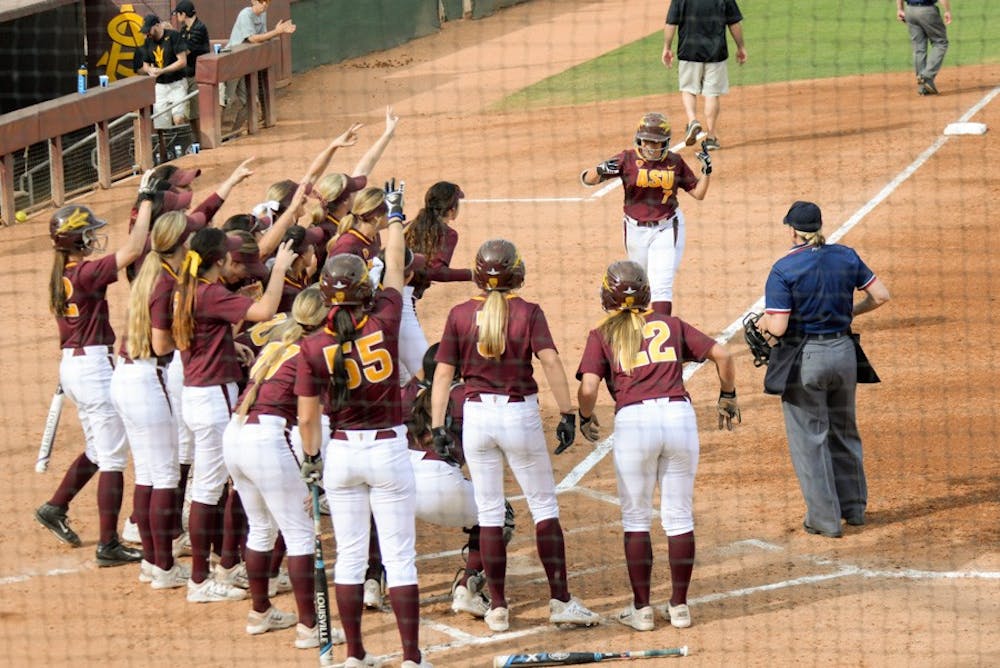 Senior Sierra Rodriguez is greeted at home plate by the Sun Devil team after her home run Sunday, Feb. 15, 2015, at Farrington Stadium in Tempe. The Sun Devils would go on to defeat the Sooners due to strong offense and solid defense. (J. Buaer-Leffler/The State Press)