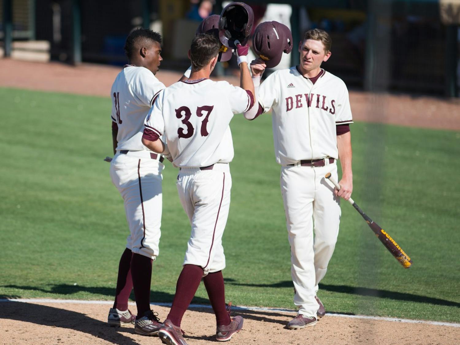 Junior shortstop Colby Woodmansee taps helmets with his teammates after hitting a home run during a game against USC on Sunday, May 29, 2016, at Phoenix Municipal Stadium in Phoenix. The Trojans defeated the Sun Devils 31-9.