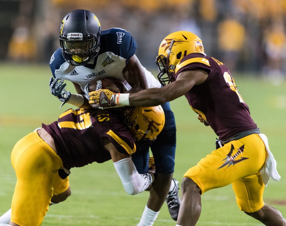 NAU's junior wide receiver is tackled by ASU's junior J'Marcus Rhodes and senior Bryson Echols in the first quarter on Saturday, Sept. 3, 20016, in Sun Devil Stadium.