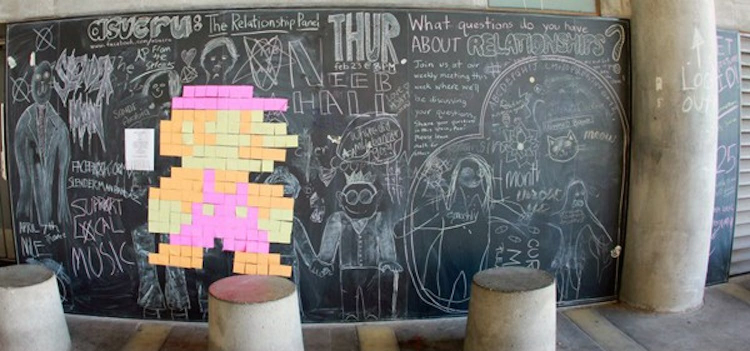 A Mario made from sticky notes decorates the chalkboard wall outside Lattie F. Coor Hall. Students can express their feelings or ideas using chalk on the wall, which is regularly erased and changed. (Photo courtesy of Justin Marshall)