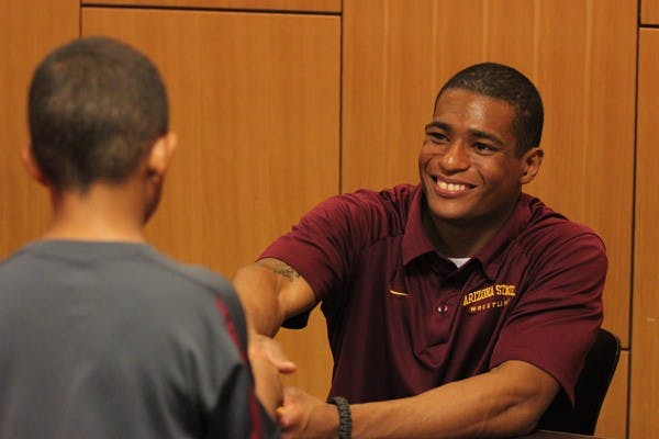 Robles introduces himself to a young fan during the signing of his book "Unstoppable" on Tuesday night at the Memorial Union. (Photo by Kyle Newman)