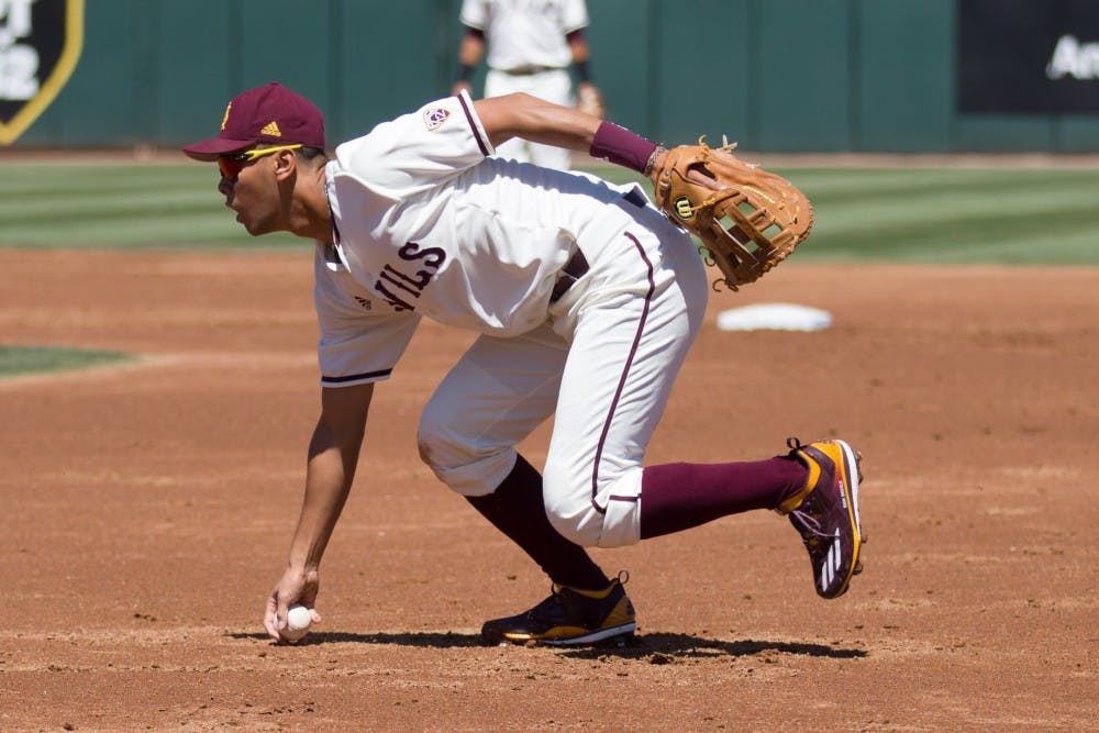 ASU freshman infielder/catcher Lyle Lin (27) picks up a ball near first base after knocking it down during game three of a baseball series against the UCLA Bruins at Phoenix Municipal Stadium in Phoenix on April 2, 2017.