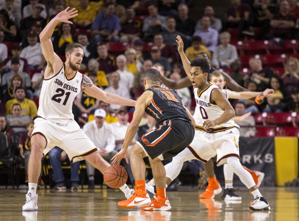 Beaver Malcolm Duvivier is guarded by Arizona State Sun Devils forward Eric Jacobsen (21) and Arizona State Sun Devils guard Tra Holder (0) during a game against the Oregon State Beavers at Wells Fargo Arena in Tempe, Arizona, on Thursday, Jan. 28, 2015. The Sun Devils took the win over the Beavers, 86-68.