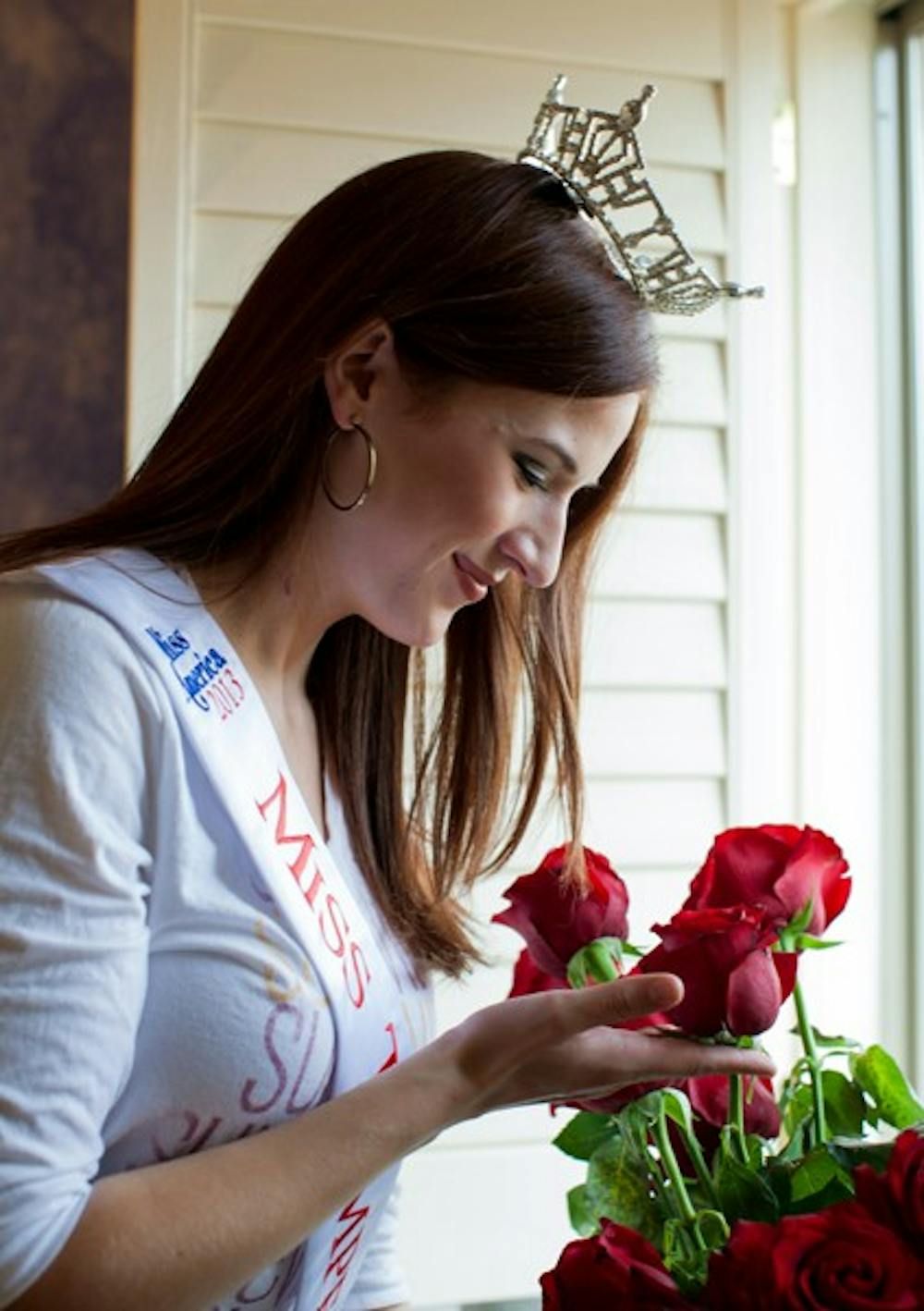 ASU grad student Andrea Malinski admires the roses she got from the pageant and from her boyfriend when she was crowned Miss Tempe one week ago. (Photo by Perla Farias)