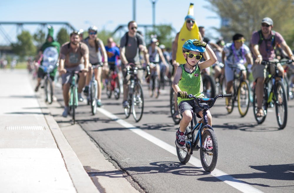 Bikers ride down W Rio Salado Pkwy during the bike parade on Saturday, Oct. 3, 2015. The annual Tour de Fat celebration features a costumed bike parade around Tempe.