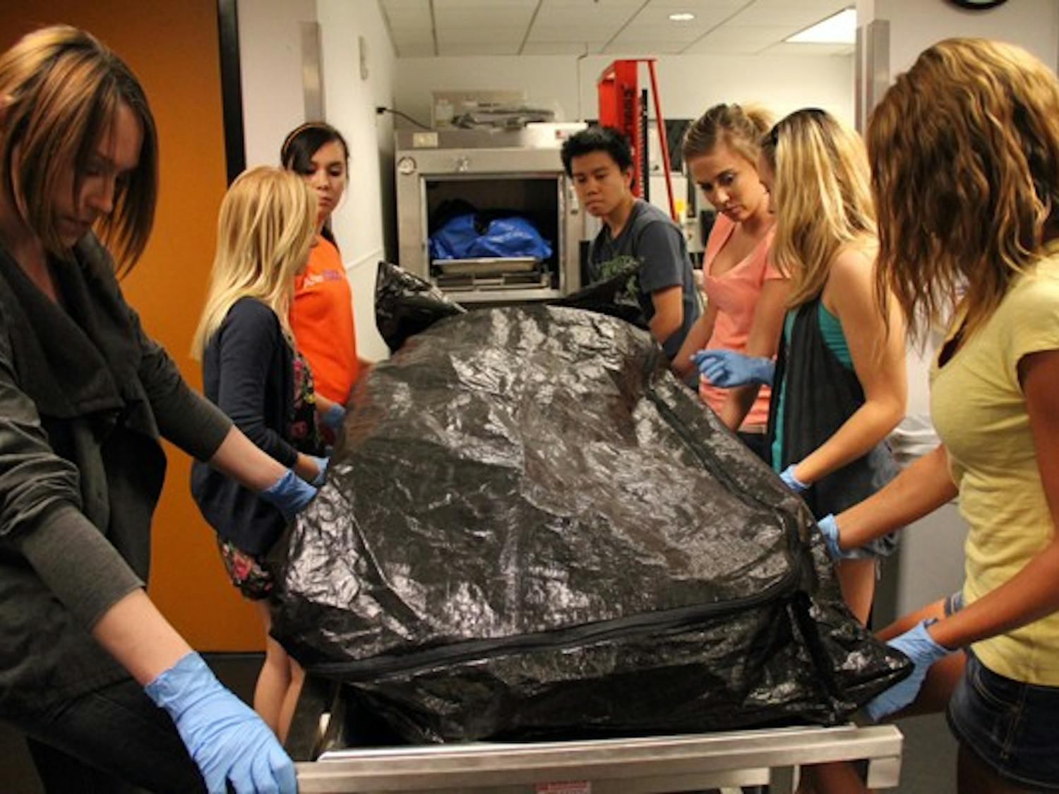 ASU students in BIO 494 use a forklift to move cadavers into a freezer in the University Center Building on the Downtown campus Wednesday afternoon. The students are studying bodies to learn about the human anatomy. (Photo by Diana Lustig)