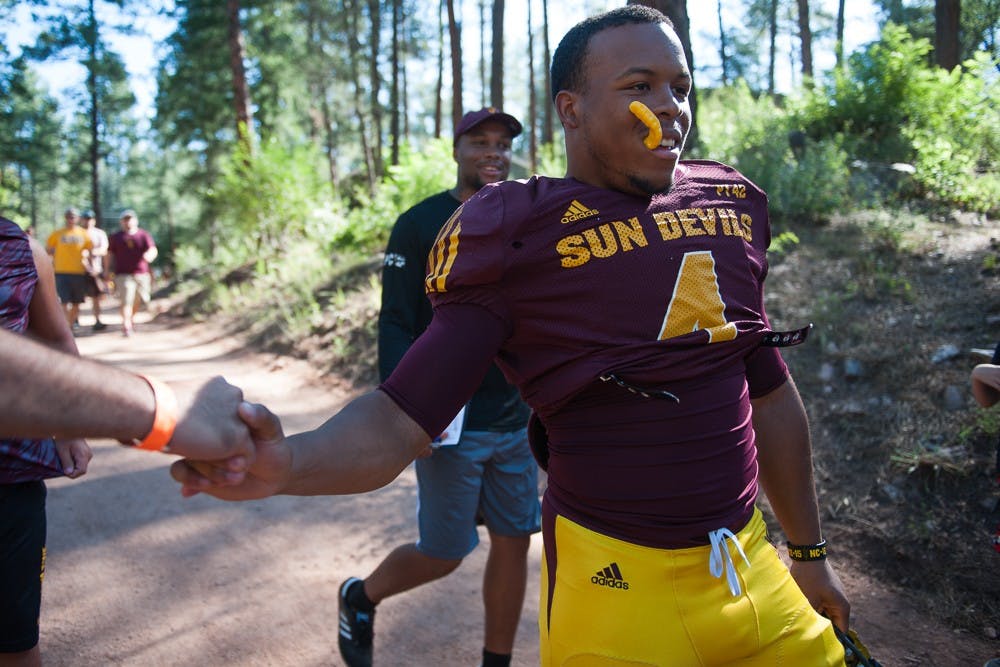 Sophomore running back Demario Richard shakes a fan's hand during the last day of Camp Tontozona on Saturday, Aug. 15, 2015, in Payson, Arizona.