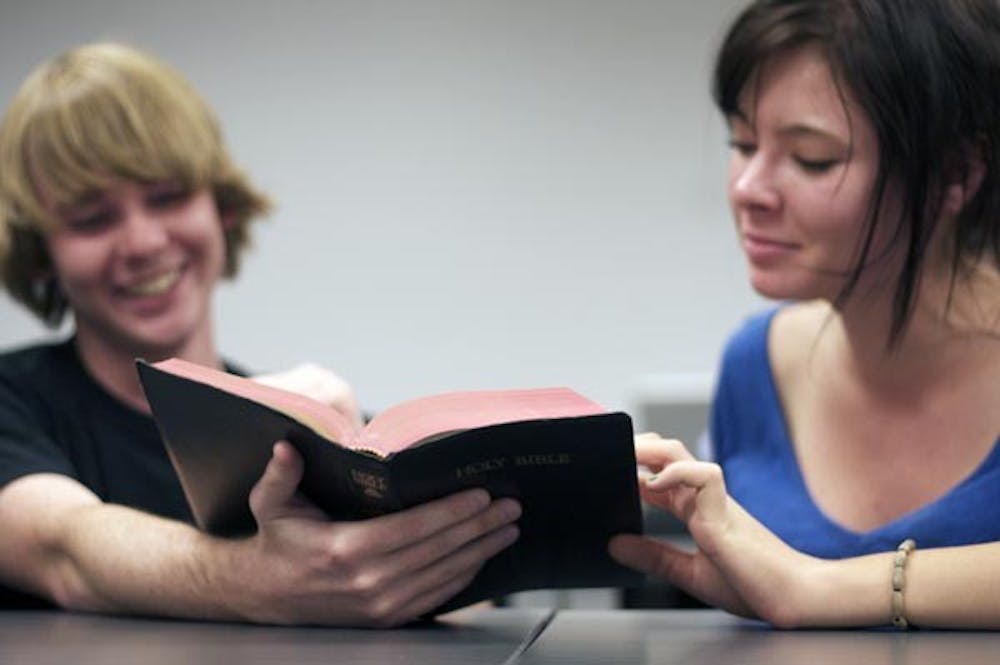 FOOD FOR THOUGHT: Freshman Tom MacLean (left) and Chelsea Moreno (right), members of Secular Freethought Society, discuss parts of the Bible at their Thursday night meeting. (Photo by Scott Stuk)