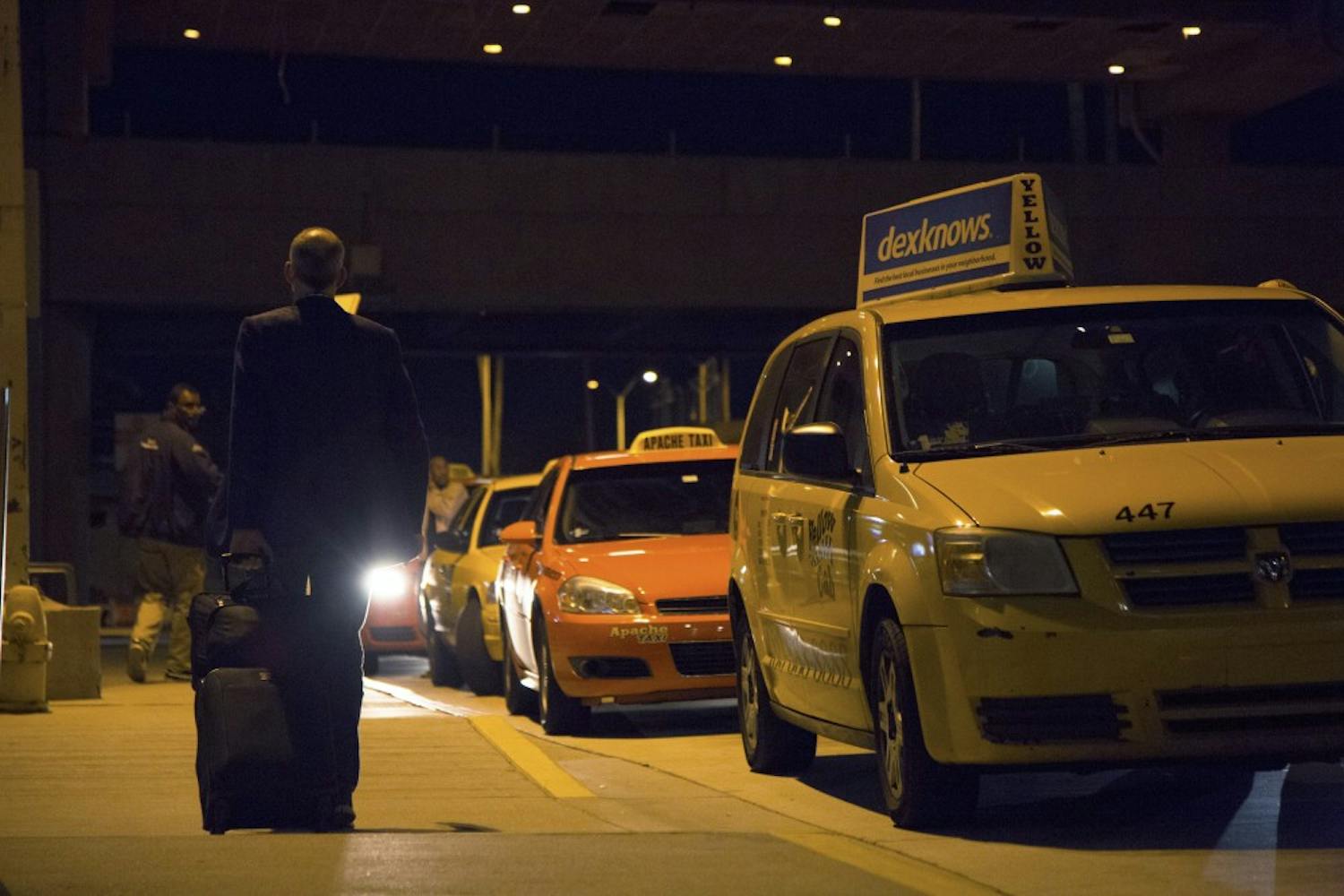 A man walks along the curb of the taxi pickup lane at  Phoenix Sky Harbor International Airport  in Phoenix, on Wednesday, Jan. 20, 2016.