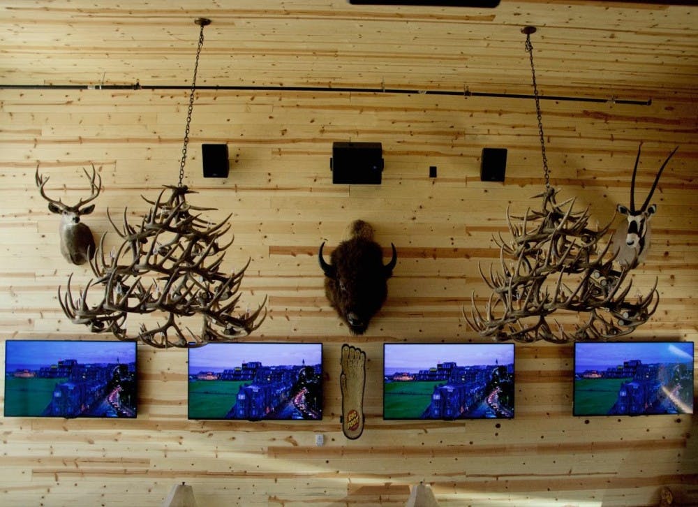 The interior of The Lodge Sasquatch Kitchen contains 30 televisions for guest entertainment. The decor displays wooden walls with mountainous taxidermy.
