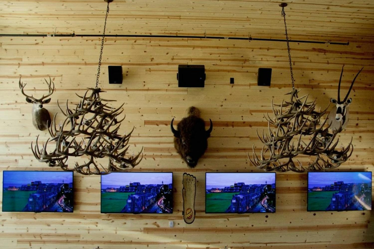 The interior of The Lodge Sasquatch Kitchen contains 30 televisions for guest entertainment. The decor displays wooden walls with mountainous taxidermy.