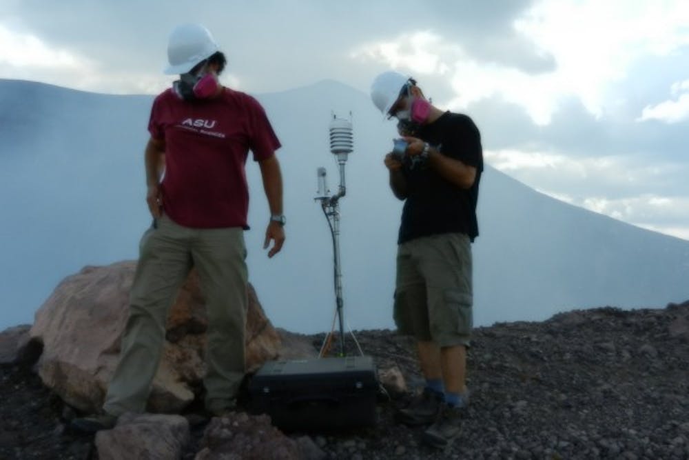 Alberto Behar (left) and Andres Mora set up monitoring equipment on the Telica volcano in Leon, Nicaragua. (Photo courtesy of Andres Mora)