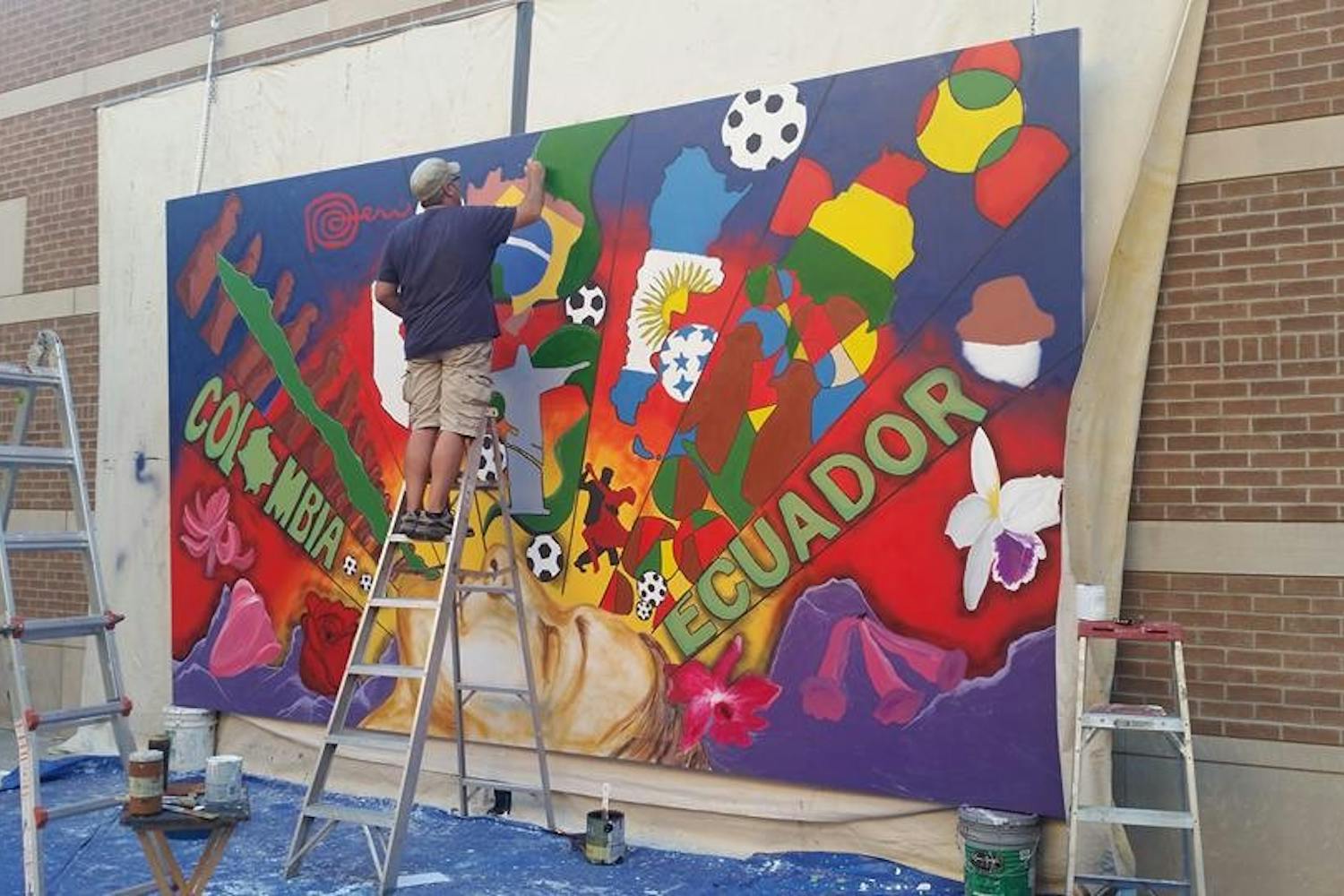 Local artist Hugo Medina&nbsp;works on the mural he designed for last year's&nbsp;Hispanic Heritage Month on Oct. 2, 2015. The mural is hanging on the West campus for this year's celebration as well.