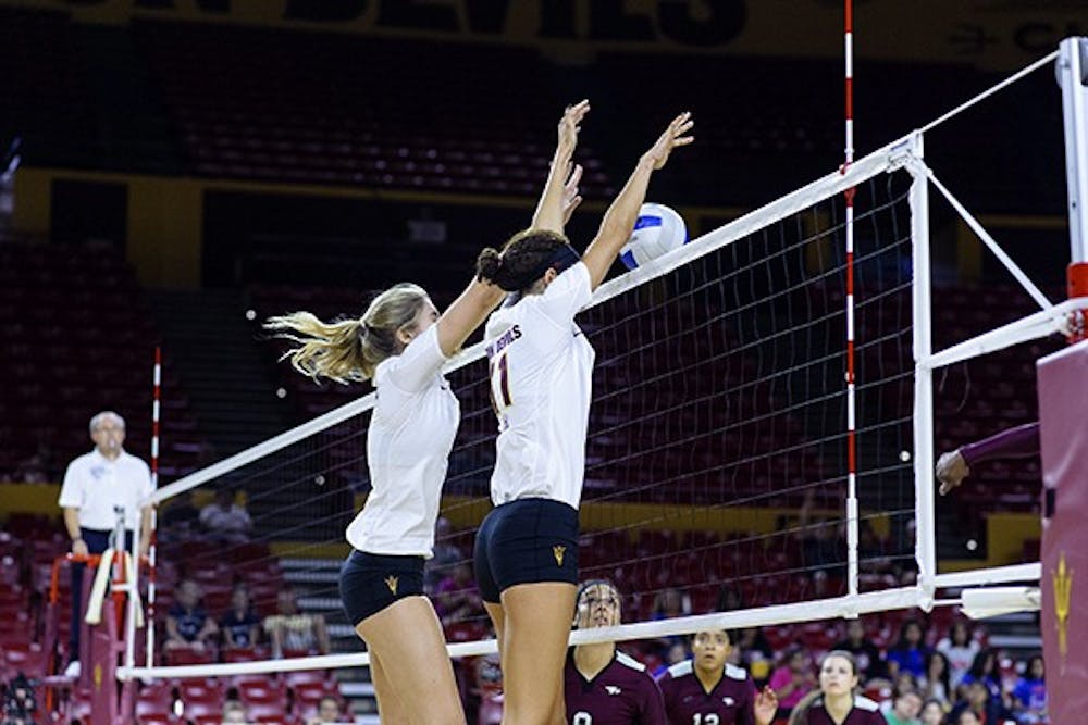 Sophomore outside hitter BreElle Bailey blocks a hit to win the match point against North Carolina Central University on Saturday, Sept. 20, 2014, at Wells Fargo Arena in Tempe. The Sun Devils swept the Eagles 3-0. (Photo by Ben Moffat)