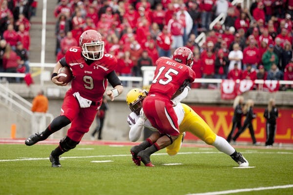 TRIAL BY FIRE: Utah junior quarterback Jon Hays (left) carries the ball out of the pocket as junior running back John White blocks off an ASU defender in the Utes’ 35-14 loss to the Sun Devils. Hays threw for 199 yards with one touchdown and three interceptions in his first start of the season. (Photo courtesy of Nathan Sweet | The Daily Utah Chronicle)