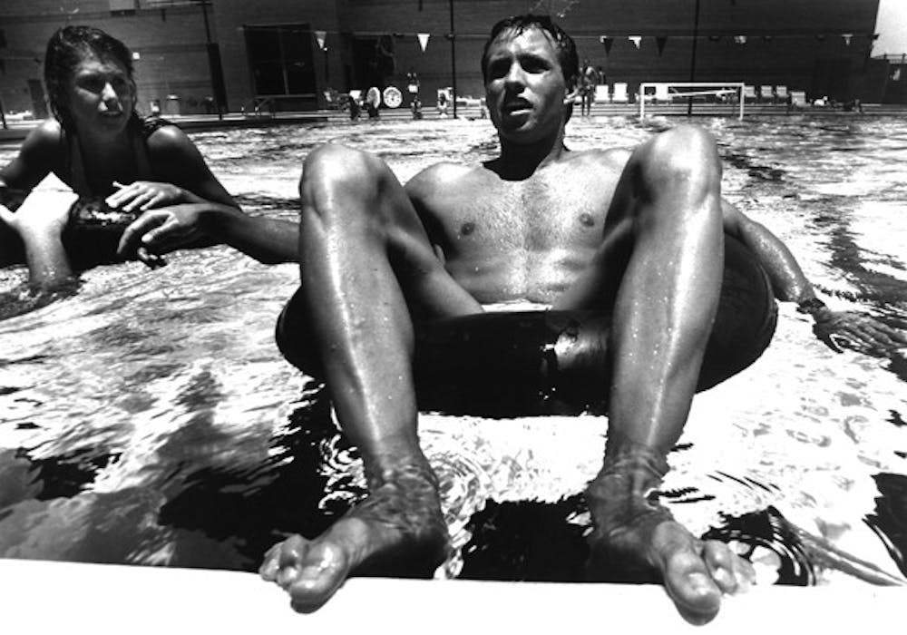 TUBE TEACHERS: Seniors Brad Senska and Michelle Danko prepare for their inner tube relay race at the Student Recreation Center pool on June 20, 1990.  Students in the summer physical education were required to teach one game to other students. (Photo by T.J. Sokol)