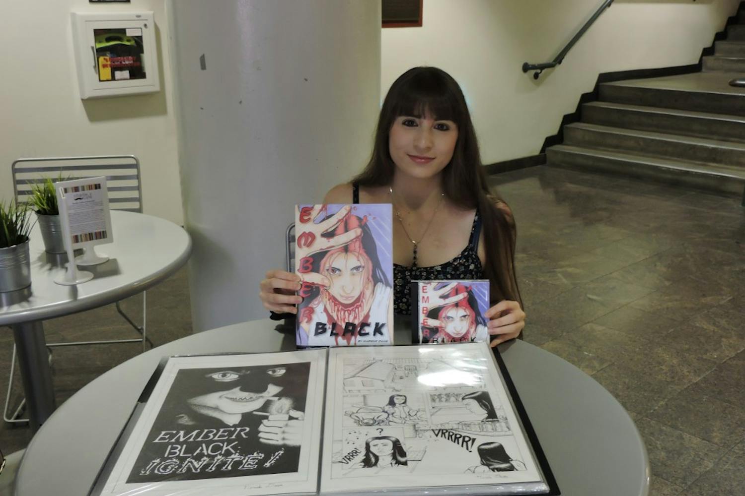 Comic book artist Marieke Davis poses for a photo with her art on Thursday, Nov. 10.&nbsp;