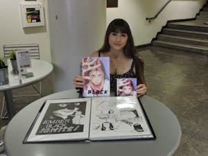 Comic book artist Marieke Davis poses for a photo with her art on Thursday, Nov. 10.&nbsp;