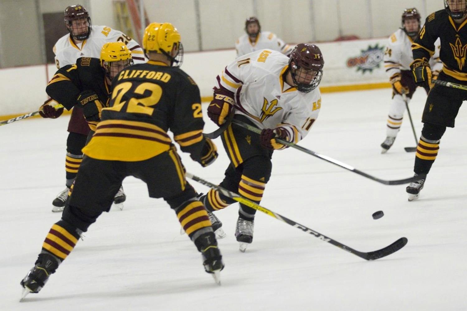 ASU freshman left winger Jack Rowe (11, maroon) controls the puck with sophomore right defender Jake Clifford (22, gold) looking to stop him during the annual Maroon and Gold Scrimmage at Oceanside Ice Arena, in Tempe, Arizona on Saturday, Oct. 1, 2016. The maroon team won 4-3 in overtime.