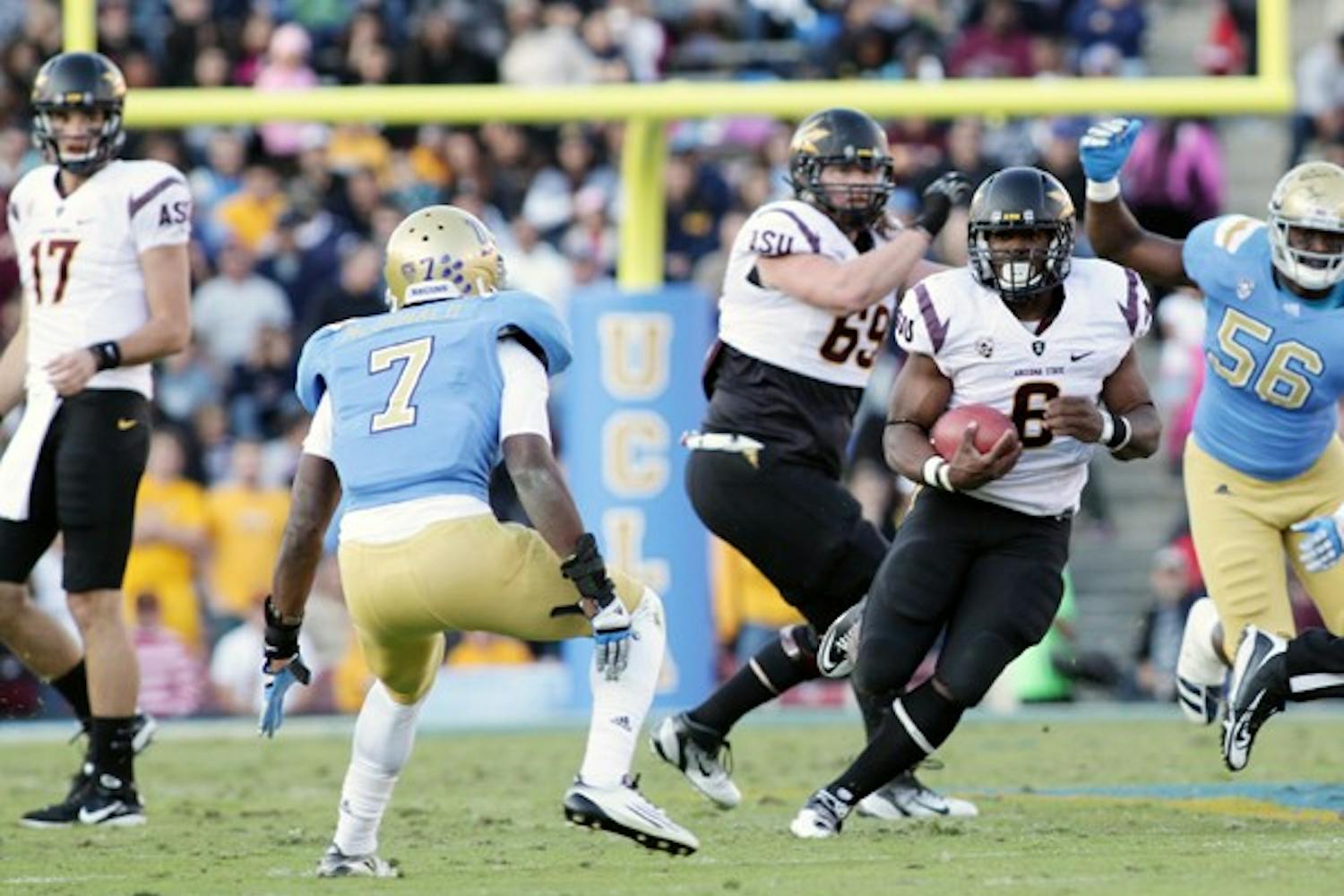 ROADBLOCK: ASU junior running back Cameron Marshall (6) tries to run around UCLA free safety Tevin McDonald (7) during the Bruins’ 29-28 upset over the Sun Devils on Saturday. The win over ASU gave UCLA the Pac-12 South lead with three games remaining for both teams’ respective seasons. (Photo by Beth Easterbrook)