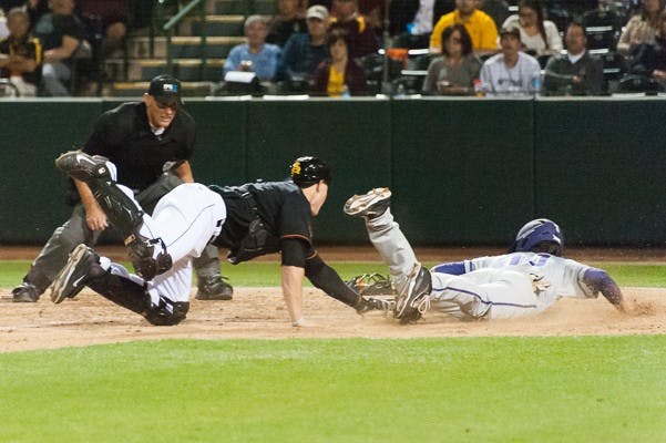 ASU sophomore catcher Brian Serven throws out TCU junior left fielder Dane Steinhagen at home plate on Friday, Feb. 20, 2015, at Phoenix Municipal Stadium. The Horned Frogs will be hosting a regional in the 2015 NCAA baseball postseason. (Ben Moffat/The State Press)