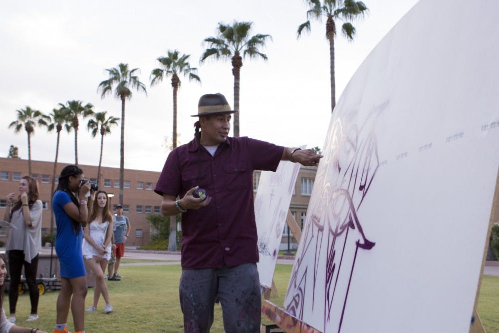 Graffiti artist Randy B sprays on a fresh canvas in Tempe's Hayden Lawn. Students participated in a graffiti clinic led by B on Monday at the Tempe campus to launch a week of events under the Urban Sol movement. (Photo by Dominic Valente)