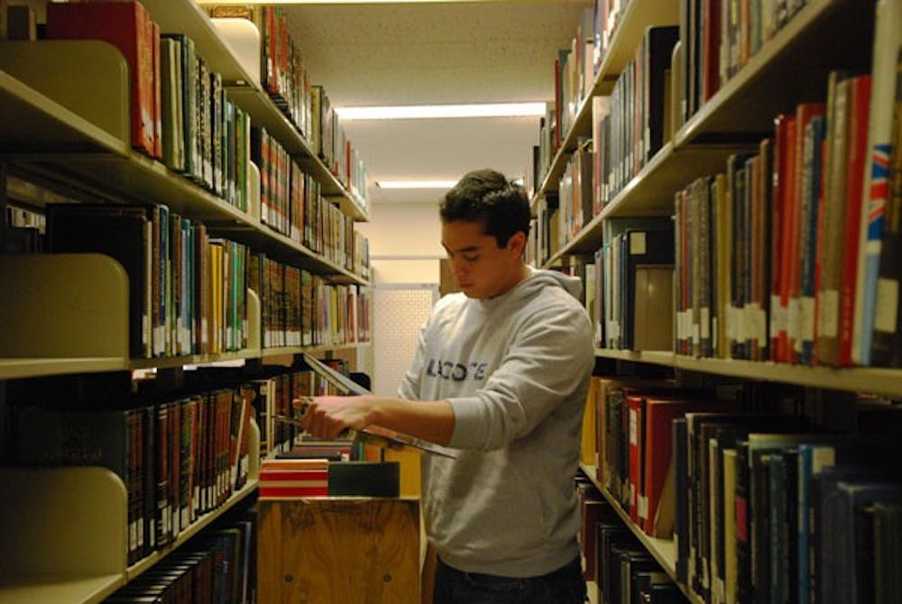 Student worker, Jose David Gutierrez, an international student mastering in industrial engineering, pulls books from the special collections section of Hayden Library on Wednesday afternoon. (Photo by Murphy Bannerman)