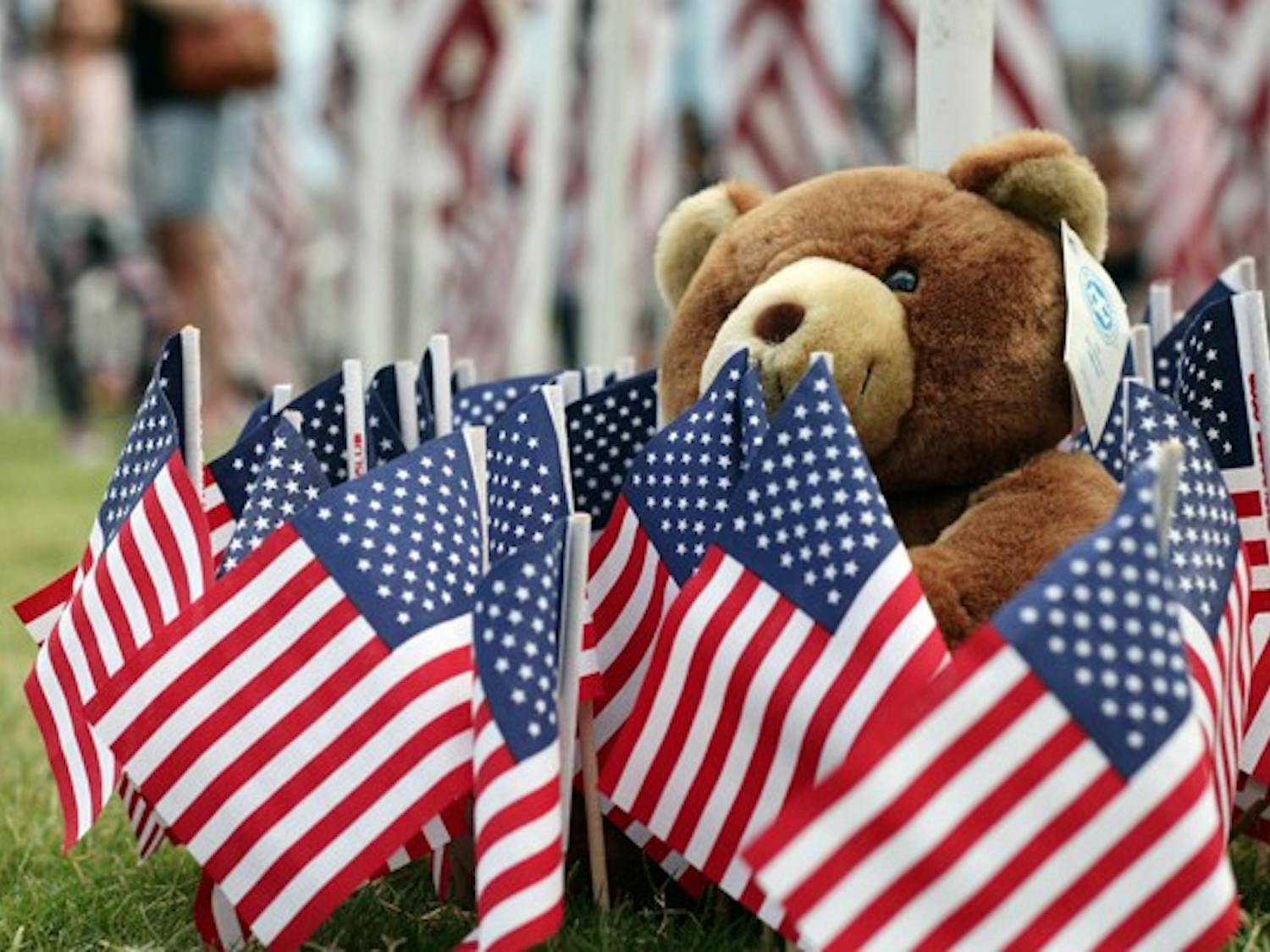 THE LITTLE THINGS: A teddy bear rests at the base of a flag at the Healing Field 9/11 Memorial at Tempe Beach Park. The memorial is the longest running annual memorial commemorating the 9/11 terrorist attacks.  (Photo by Beth Easterbrook)