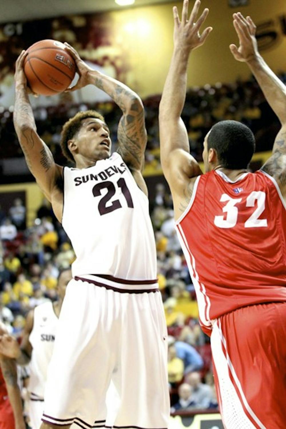ASU sophomore guard Keala King (left) goes up for a layup against New Mexico senior forward Drew Gordon during the Sun Devils 76-71 loss to the Lobos on Nov. 17. The Sun Devils finished the Old Spice Classic in Orlando, Fla. 1-3 and are now 2-6 on the season. (Photo by Aaron Lavinsky)