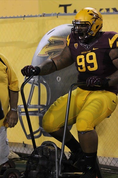 Junior defensive tackle Mike Pennel warms up on the ASU sideline during the Sun Devils’ 63-6 win over NAU on Aug. 30. (Photo by Kyle Newman)