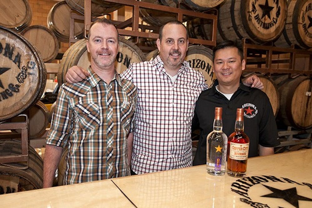 Arizona Distilling Co. owners Jon Eagan, Jason Grossmiller, and Rodney Hu pose in front of their Copper City Bourbon and newest product, Desert Dry Gin.  (Photo by Mario Mendez)