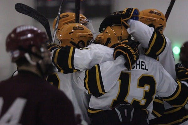 Several members of the ASU club hockey team celebrate in a huddle during a break in the Sun Devils’ 13-0 win over Texas A&M on Sept. 20. (Photo by Kyle Newman)