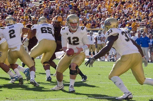 HAND TO HAND: Sophomore quarterback Richard Brehaut hands the ball off to junior tailback Derrick Coleman during Friday's 55-34 loss to ASU. Brehaut threw for 321 yards and three touchdowns in the game. (Photo by Aaron Lavinsky)