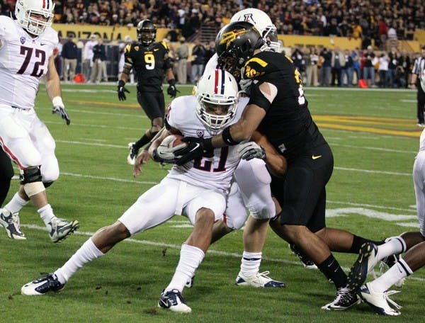 ASU senior linebacker Colin Parker wraps up UA senior wide receiver Gino Crump during the Sun Devils’ 31-27 loss to the Wildcats on Saturday. Parker said in practice on Tuesday that the defense is trying to fix its inconsistencies before the Sun Devils face California on Friday. (Photo by Beth Easterbrook)