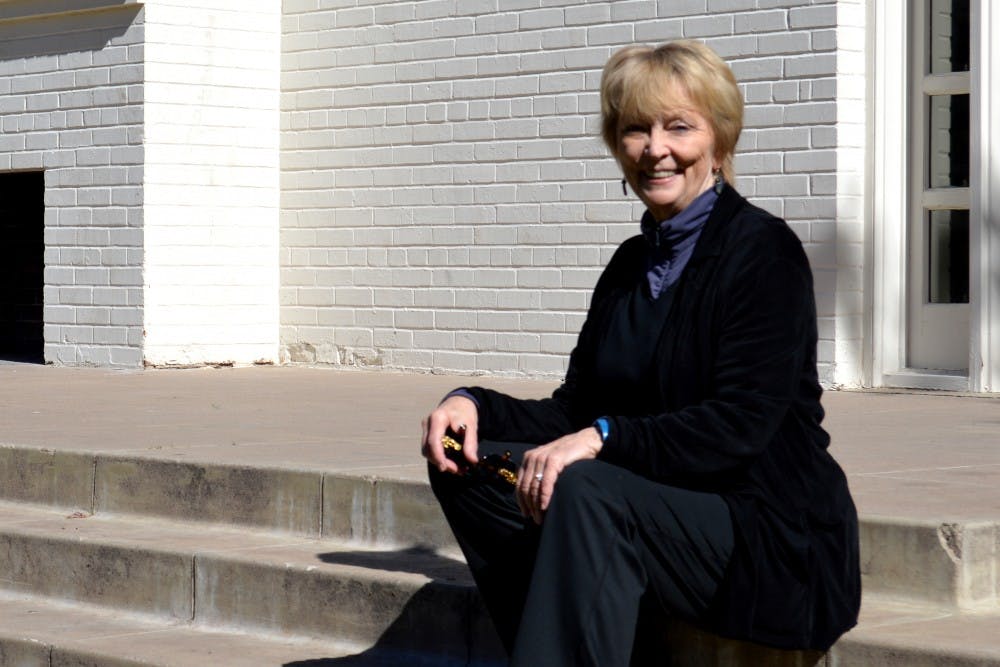 Bonnie Eckard, a theater proffesor, sitting on stairs in the gar