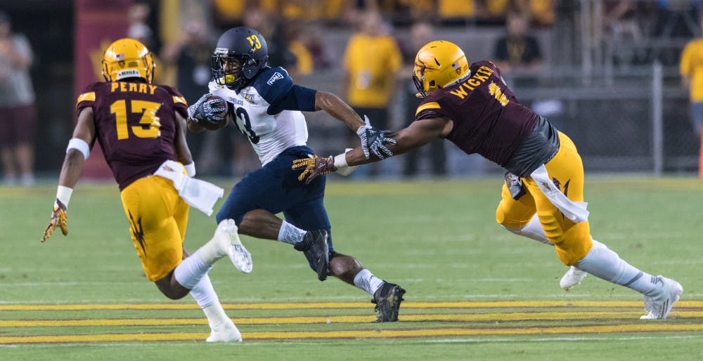 NAU's Kendal Taylor scrambles away from ASU's Soph tight end JoJo Wicker and red shirt sophmore free safety Armand Perry in the first quarter on Saturday, Sept. 3, 20016, in Sun Devil Stadium.