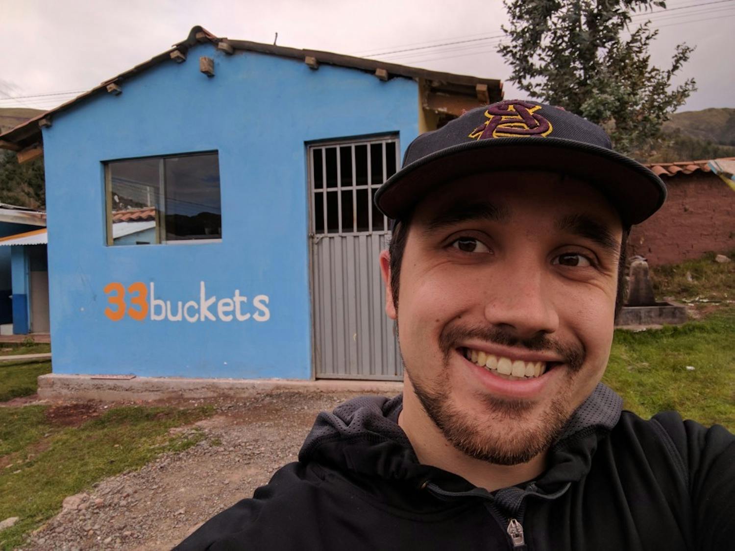 Paul Strong poses for a photo in front of a structure that houses the water filtration system he and&nbsp;his team, 33 Buckets, designed.