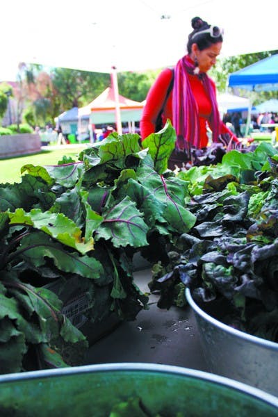 Professor of Theater and Film Carla Melo checks out some fresh vegetables provided by Taste of Paradise at the Farmers Market on the Tempe campus Tuesday afternoon. (Photo by Shawn Raymundo)