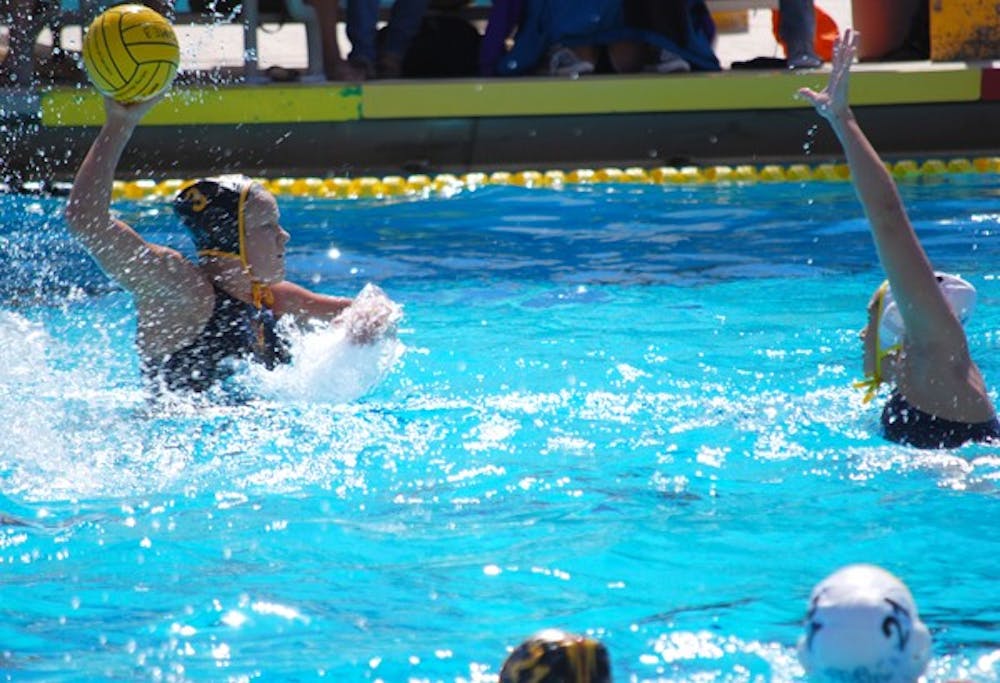 Redshirt senior attacker Alicia Brightwell reaches high to shoot over a UCLA defender on March 2.  With eight more goals Brightwell can break the ASU water polo record for goals in one season.  (Photo by Murphy Bannerman)