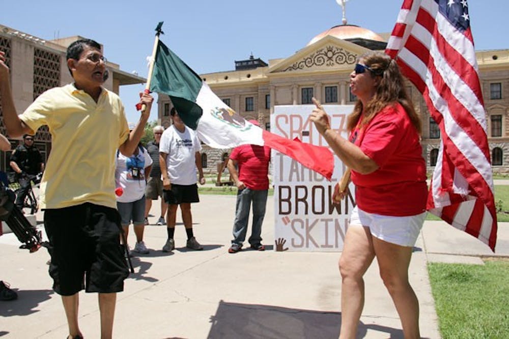 Andy Hernandez from El Mirage and Allison Culver of Glendale get into a heated argument outside of the Arizona State Capital building Monday morning over immigration issues in the U.S. after the Supreme Court's split decision to block parts but uphold one key provision of Senate Bill 1070. (Photo by Shawn Raymundo)
