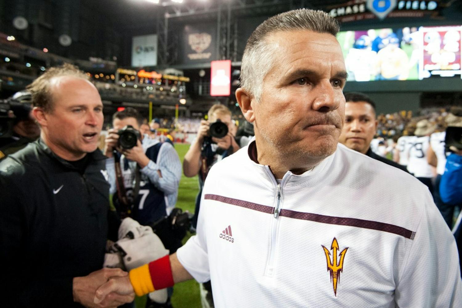 Head coach Todd Graham (right) shakes hands with West Virginia head coach Dana Holgerson after the Motel 6 Cactus Bowl on Sunday, Jan. 3, 2016, at Chase Field in Phoenix.