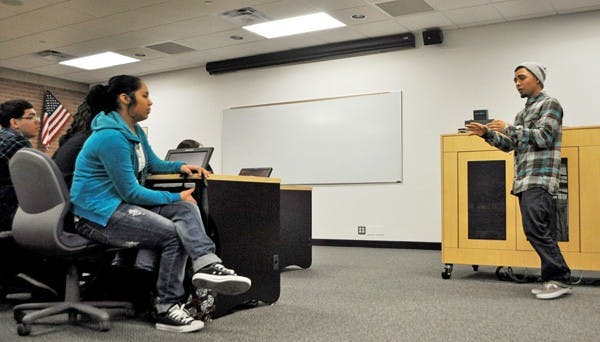 CREATIVE PASSION: Local artist Joseph "Sentrock" Perez gets choked up while speaking to students from South Mountain High School about his family history and the inspiration for his art. (Photo by Sierra Smith)