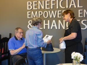 Cafe manager&nbsp;Mandy Tomasello shows customers a menu at Beneficial Beans on March 13.&nbsp;The cafe, located in Burton Barr Central Library in Downtown Phoenix, is a social enterprise that helps autistic adults find jobs.&nbsp;