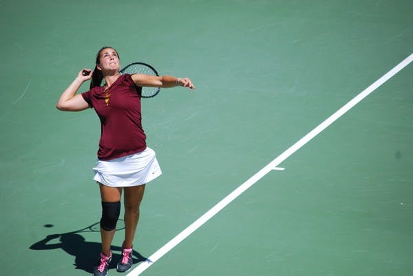 Senior Nicole Smith loads up to swing through a serve sporting a knee brace against UCLA on April 6. Smith struggled with knee injuries during her career at ASU. (Photo by Murphy Bannerman)