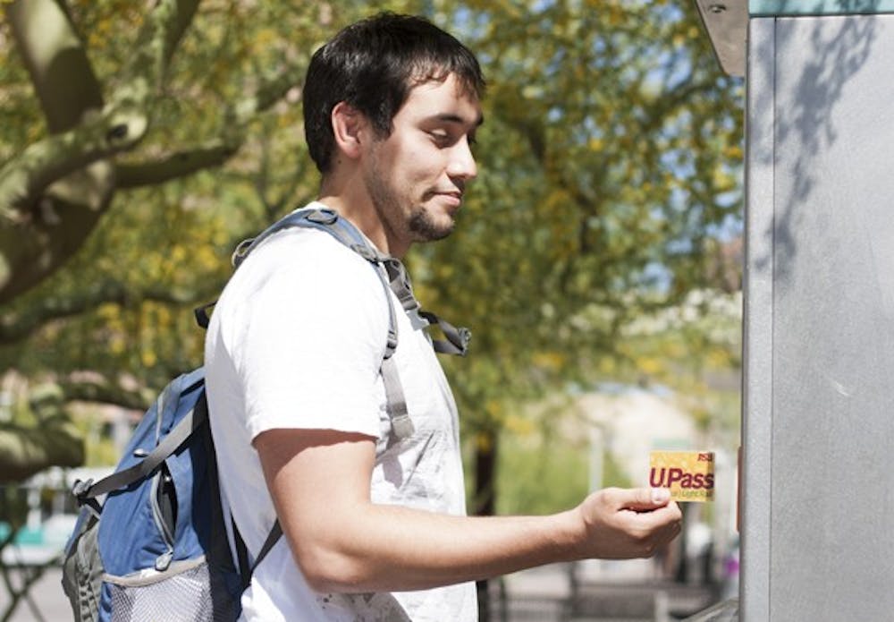 Junior Brian Jarvis, a Nutrition major, uses his U-Pass at the lightrail station on Van Buren and 1st Avenue. He says although he prefers a lower price for the pass, he knows that either way he is going to have to pay whatever amount the fee changes to. (Photo by Perla Farias)