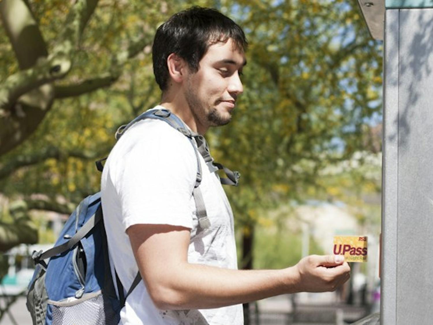 Junior Brian Jarvis, a Nutrition major, uses his U-Pass at the lightrail station on Van Buren and 1st Avenue. He says although he prefers a lower price for the pass, he knows that either way he is going to have to pay whatever amount the fee changes to. (Photo by Perla Farias)