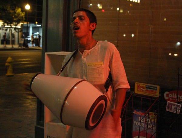 SERWAA ADU-TUTU | THE STATE PRESSHARE KRISHNA: Janardan Das bangs his drum and chants on Mill Avenue Friday night, inviting passersby to visit the Hare Krishna Temple in Chandler. 