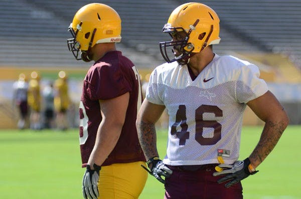 Junior linebacker Kipeli Koniseti rests during a break at the Sun Devils’ practice at Sun Devil Stadium on Thursday. Koniseti won the respect of his teammates for raising a family while being a full-time student and member of the ASU football team. (Photo by Aaron Lavinsky)
