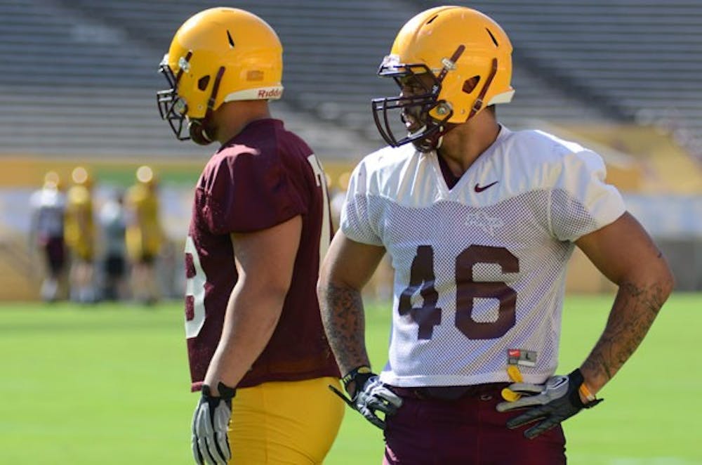Junior linebacker Kipeli Koniseti rests during a break at the Sun Devils’ practice at Sun Devil Stadium on Thursday. Koniseti won the respect of his teammates for raising a family while being a full-time student and member of the ASU football team. (Photo by Aaron Lavinsky)
